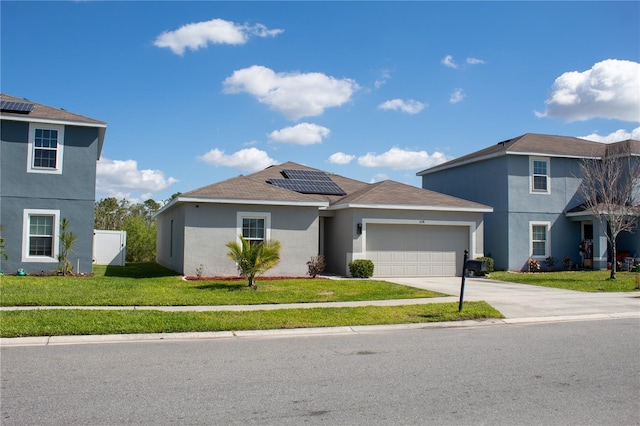 view of front of property with driveway, an attached garage, roof mounted solar panels, a front lawn, and stucco siding