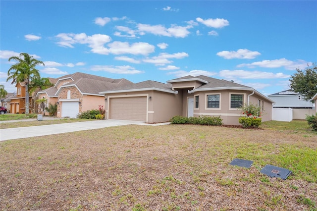 view of front facade with a front yard, driveway, an attached garage, and stucco siding