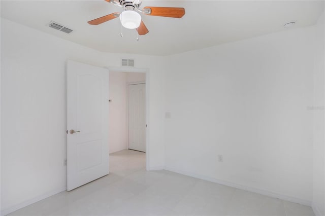 spare room with ceiling fan, visible vents, and baseboards