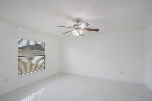 empty room featuring a ceiling fan and baseboards