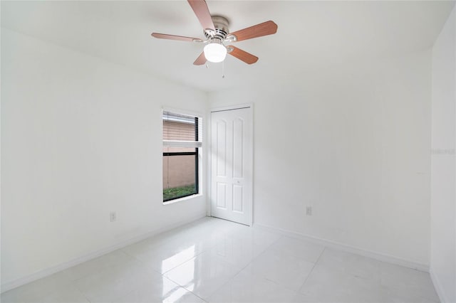 unfurnished room featuring light tile patterned floors, ceiling fan, and baseboards