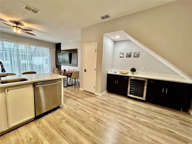 kitchen with a sink, beverage cooler, visible vents, and dishwasher