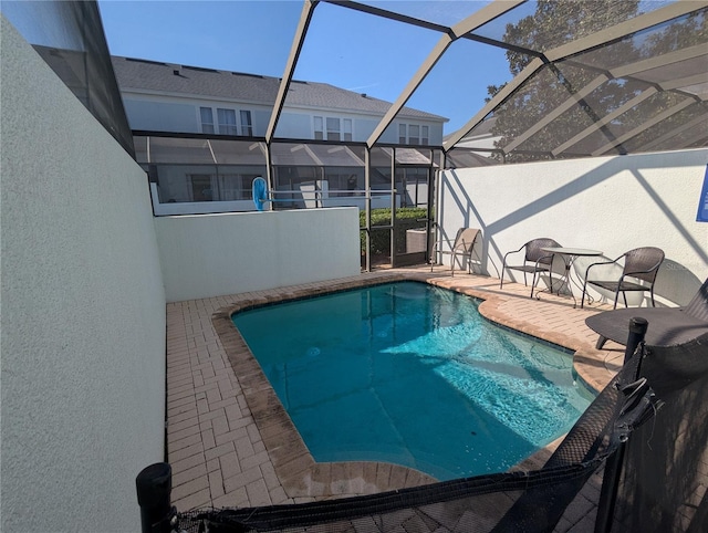 pool with glass enclosure and a patio