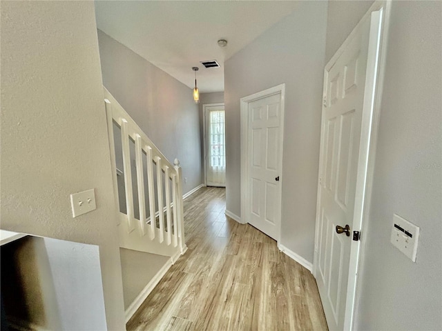 foyer featuring light wood-type flooring, visible vents, stairs, and baseboards