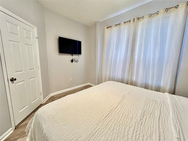 bedroom featuring wood finished floors and baseboards