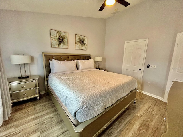 bedroom featuring a ceiling fan, lofted ceiling, baseboards, and wood finished floors