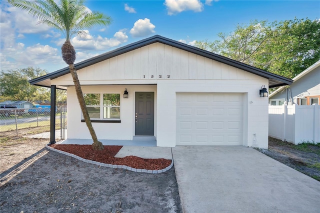 ranch-style house with concrete driveway, an attached garage, and fence