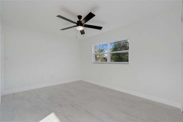 spare room featuring ceiling fan and baseboards