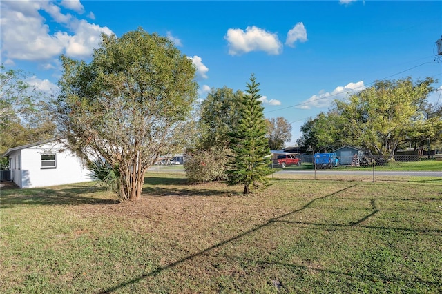 view of yard featuring a carport, cooling unit, and fence