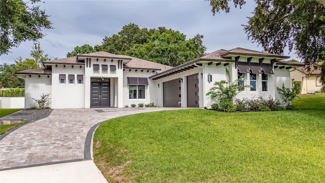 view of front of property with a garage, stucco siding, decorative driveway, and a front yard