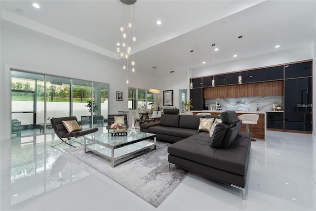 living area with a towering ceiling, light tile patterned floors, and recessed lighting