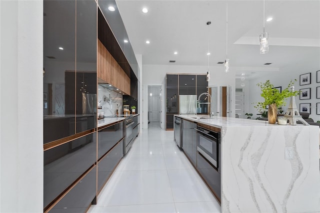 kitchen with decorative light fixtures, light tile patterned floors, a spacious island, a sink, and modern cabinets