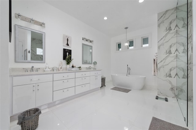 full bathroom with double vanity, a freestanding bath, a sink, and recessed lighting