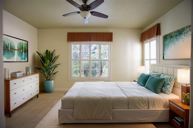 carpeted bedroom with baseboards, a textured ceiling, and ceiling fan