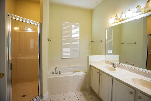 bathroom with tile patterned flooring, a shower stall, a garden tub, and a sink