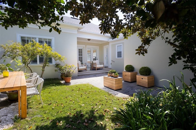 back of house featuring french doors, a yard, a patio area, and stucco siding