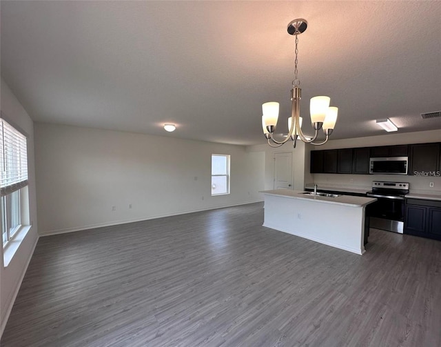 kitchen featuring a notable chandelier, stainless steel appliances, dark wood-type flooring, open floor plan, and a sink