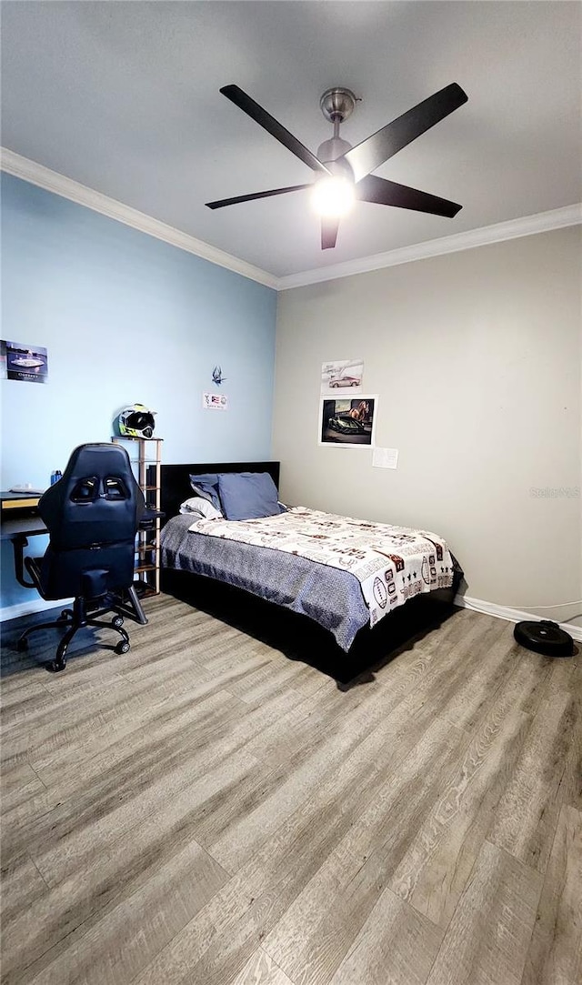 bedroom featuring a ceiling fan, baseboards, ornamental molding, and wood finished floors