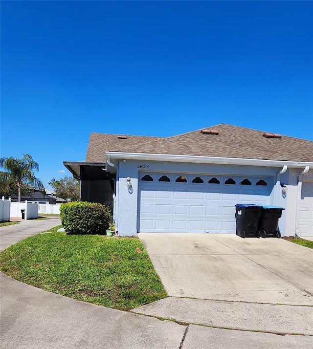 single story home with a garage, driveway, a shingled roof, and stucco siding