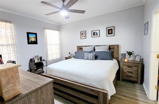 bedroom with ceiling fan, crown molding, and wood finished floors