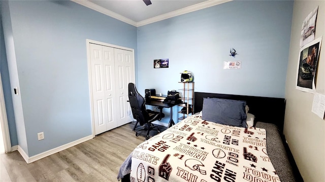 bedroom with baseboards, a ceiling fan, wood finished floors, crown molding, and a closet