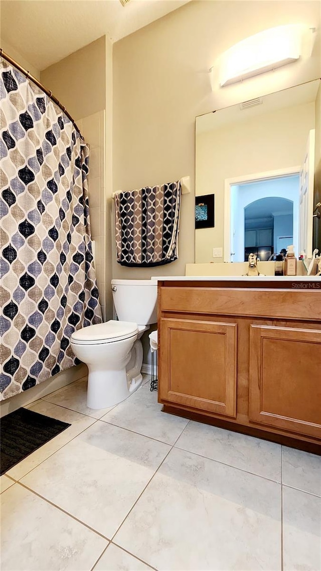 full bathroom featuring tile patterned flooring, curtained shower, vanity, and toilet