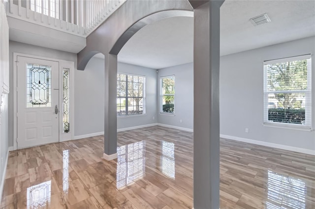 entryway with arched walkways, visible vents, and baseboards