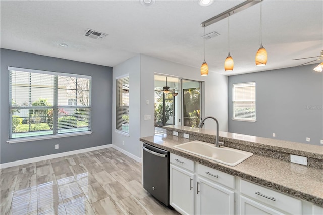 kitchen featuring visible vents, a ceiling fan, stainless steel dishwasher, pendant lighting, and a sink