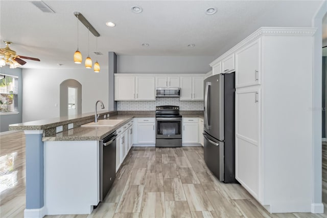 kitchen with a sink, white cabinetry, stainless steel appliances, and backsplash