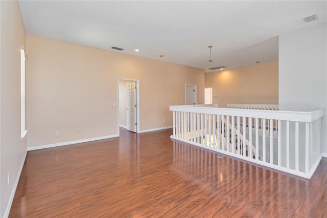 spare room featuring visible vents, baseboards, and wood finished floors