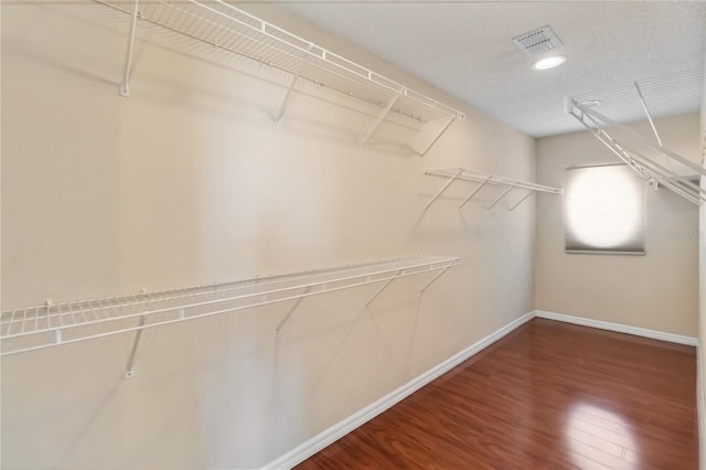 walk in closet featuring wood finished floors and visible vents