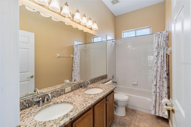 full bath with shower / tub combo with curtain, tile patterned flooring, a sink, and toilet