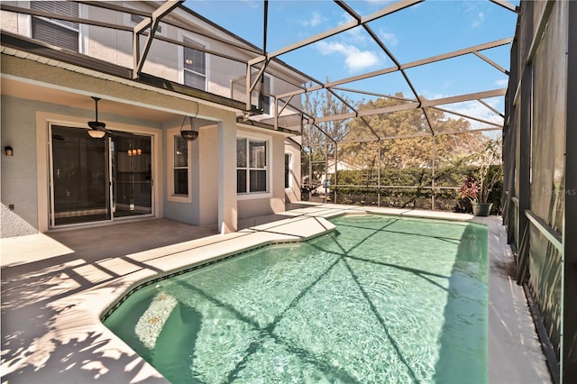 pool featuring a patio area, ceiling fan, and glass enclosure