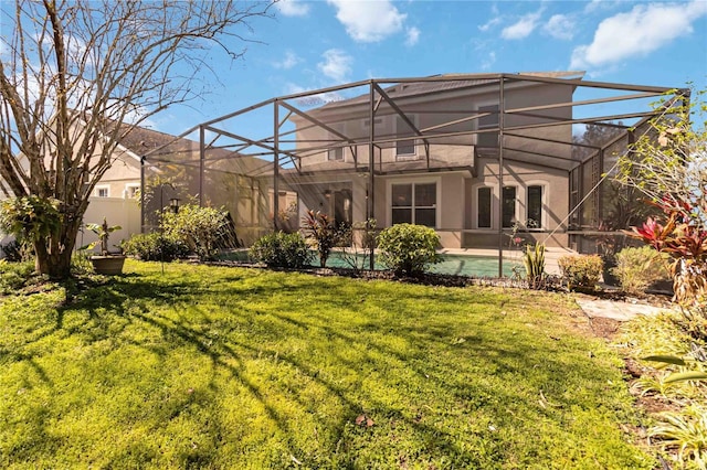 rear view of house featuring a lanai, stucco siding, an outdoor pool, and a yard