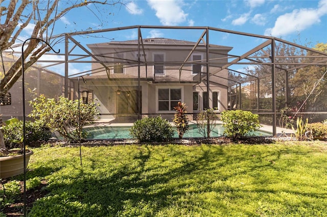 back of property with a lawn, an outdoor pool, a lanai, and stucco siding