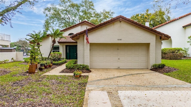 mediterranean / spanish-style house with a garage, fence, concrete driveway, a tiled roof, and stucco siding