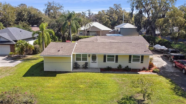 view of front of house with a shingled roof, a porch, and a front yard