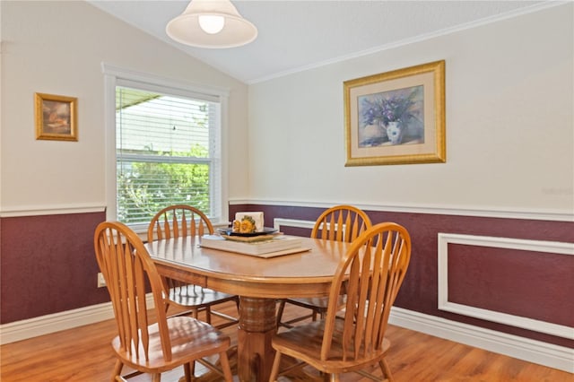 dining space featuring lofted ceiling, wood finished floors, and baseboards