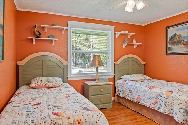 bedroom with ornamental molding, a ceiling fan, a textured ceiling, and wood finished floors