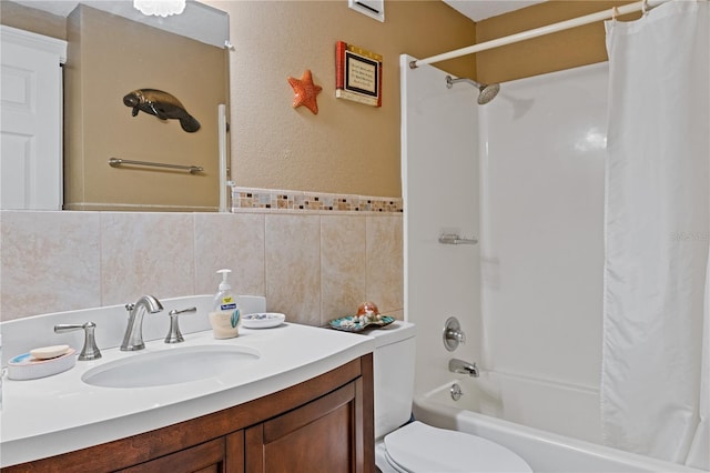 bathroom with tile walls, toilet, shower / bathtub combination with curtain, and vanity