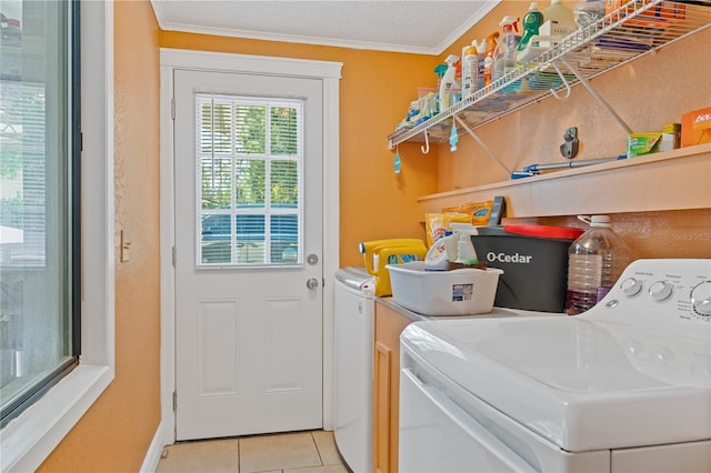 laundry room with crown molding, light tile patterned floors, washing machine and dryer, a textured ceiling, and laundry area