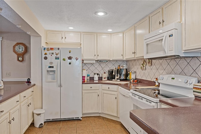 kitchen with white appliances, decorative backsplash, dark countertops, a textured ceiling, and light tile patterned flooring