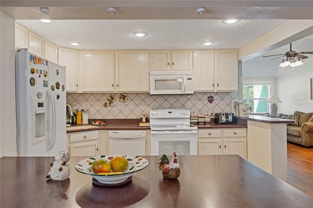 kitchen with a textured ceiling, white appliances, open floor plan, tasteful backsplash, and dark countertops