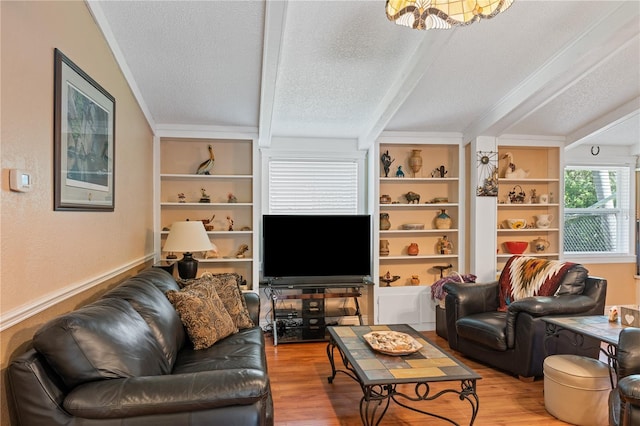 living area featuring built in features, beamed ceiling, a textured ceiling, and wood finished floors