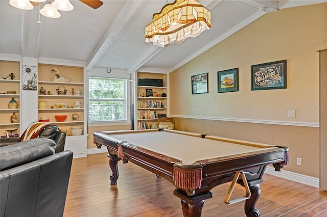 rec room with baseboards, built in features, wood finished floors, vaulted ceiling with beams, and a textured ceiling