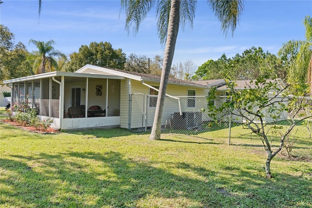 back of house featuring a sunroom, fence, and a yard