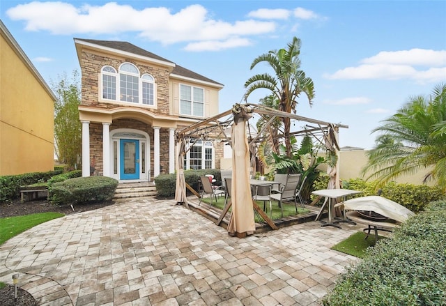 exterior space featuring stone siding, outdoor dining space, and a patio area