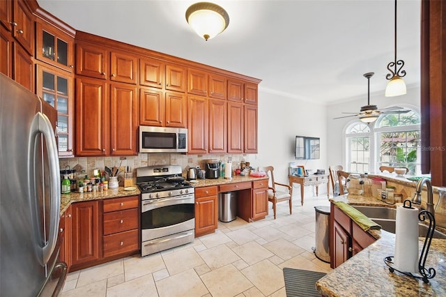 kitchen featuring glass insert cabinets, appliances with stainless steel finishes, decorative backsplash, and decorative light fixtures