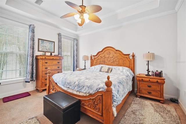 bedroom with carpet floors, baseboards, a tray ceiling, and ornamental molding