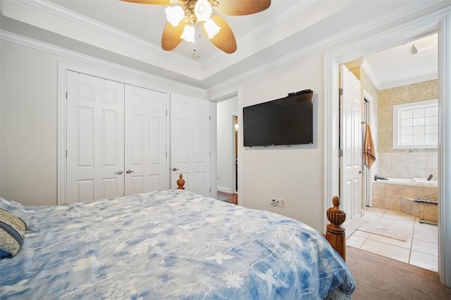 carpeted bedroom with a closet, ensuite bathroom, ornamental molding, ceiling fan, and tile patterned floors